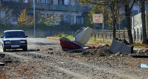 Люди едут на автомобиле рядом с поврежденным зданием после обстрела в городе Шуши (Шуша), 29 октября 2020 года. Фото: Ваграм Багдасарян/Photolure via REUTERS 