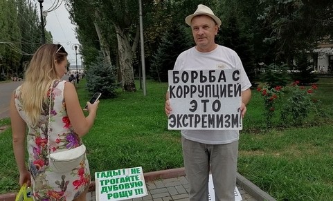 Прохожая заинтересовалась плакатом Владимира Тельпука. Волгоград, 15 августа 2021 года. Фото Татьяны Филимоновой для "Кавказского узла".