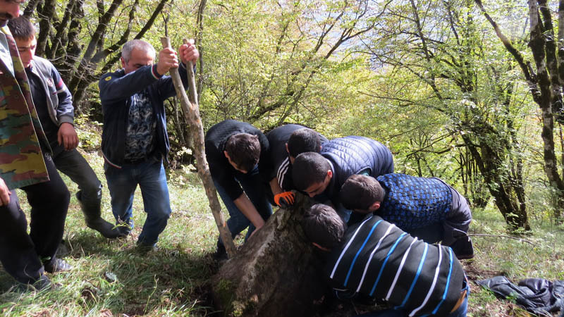 Прводник Вреж помогает мальчикам вытащить хачкар из-под земли.